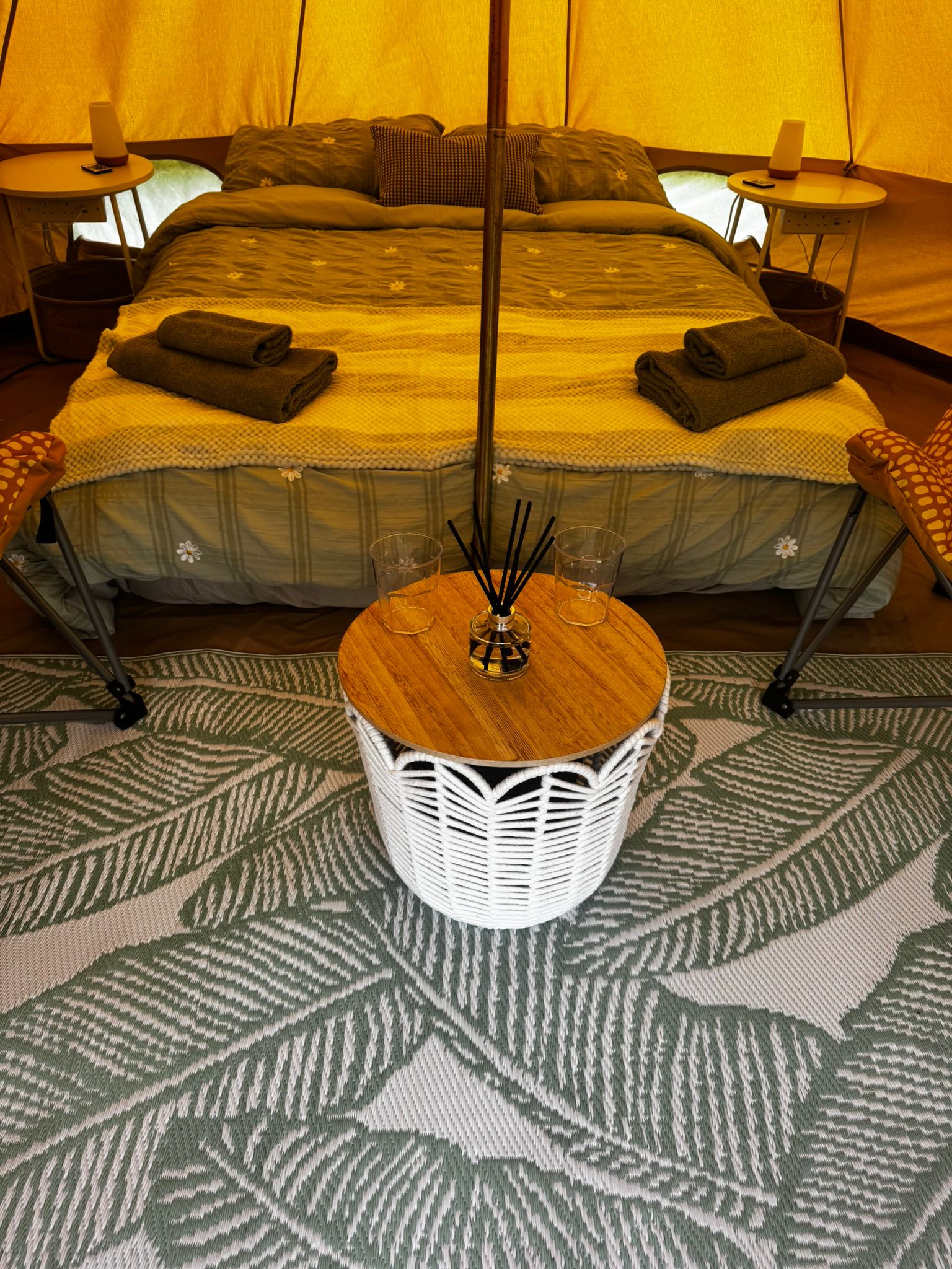 Couples glamping teepee interior with a double bed, towels, reed diffuser and candles at Ghyll House Campsite